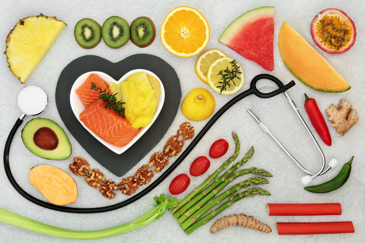 A selection of heart healthy foods on a table with a stethoscope.