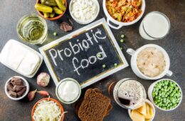 A selection of the top 20 probiotic foods on a table with a chalkboard that says 'probiotic food'.