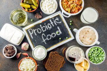 A selection of the top 20 probiotic foods on a table with a chalkboard that says 'probiotic food'.