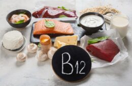 A selection of B12 rich foods on a table with a chalkboard that says B12.