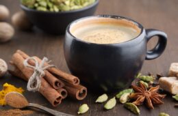 A mug of coffee on a table surrounded by spices that encourage brain function.