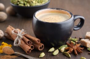 A mug of coffee on a table surrounded by spices that encourage brain function.