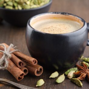A mug of coffee on a table surrounded by spices that encourage brain function.