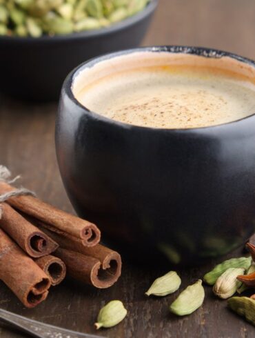 A mug of coffee on a table surrounded by spices that encourage brain function.