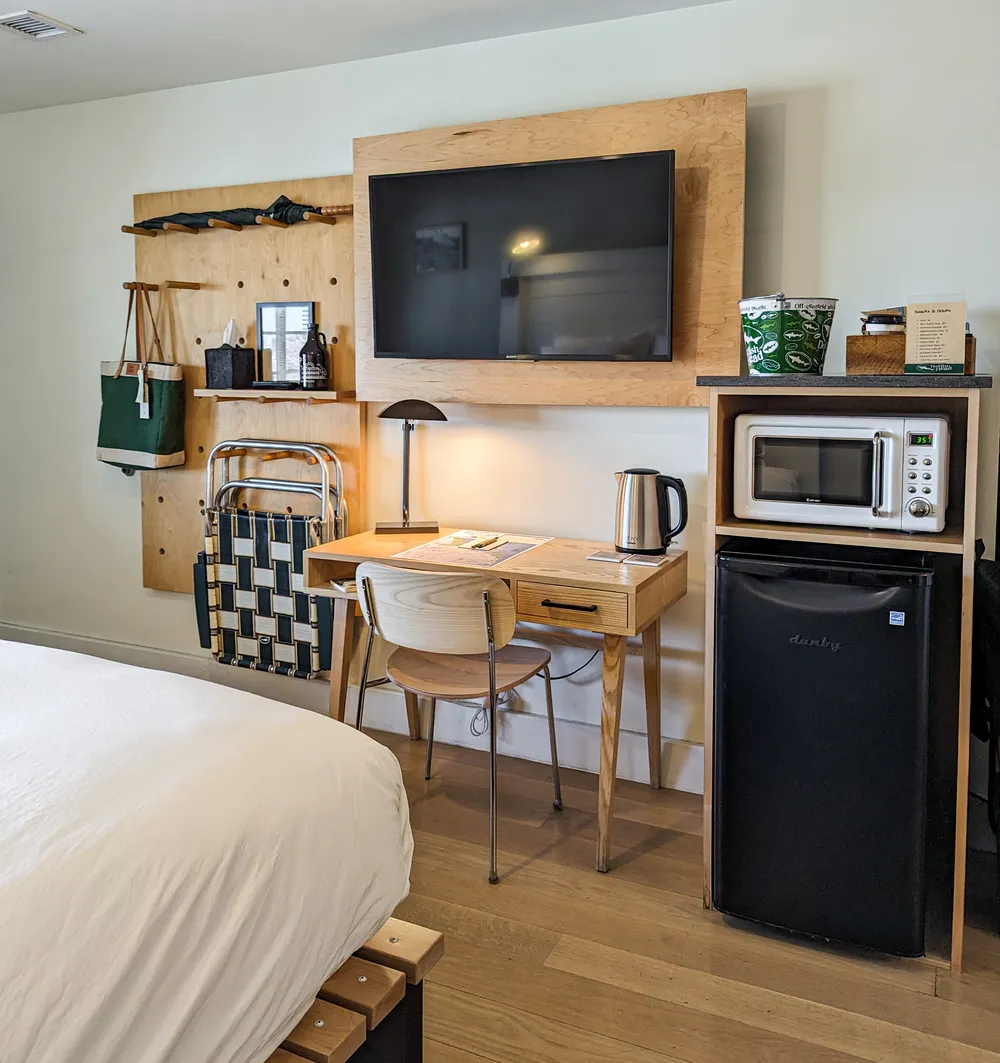 Convenient guestroom amenities at Dogfish Inn. Fridge, microwave, desk, chair, tv, lounge chairs, umbrellas, tote bag, growler, coffee pot, and more. 
