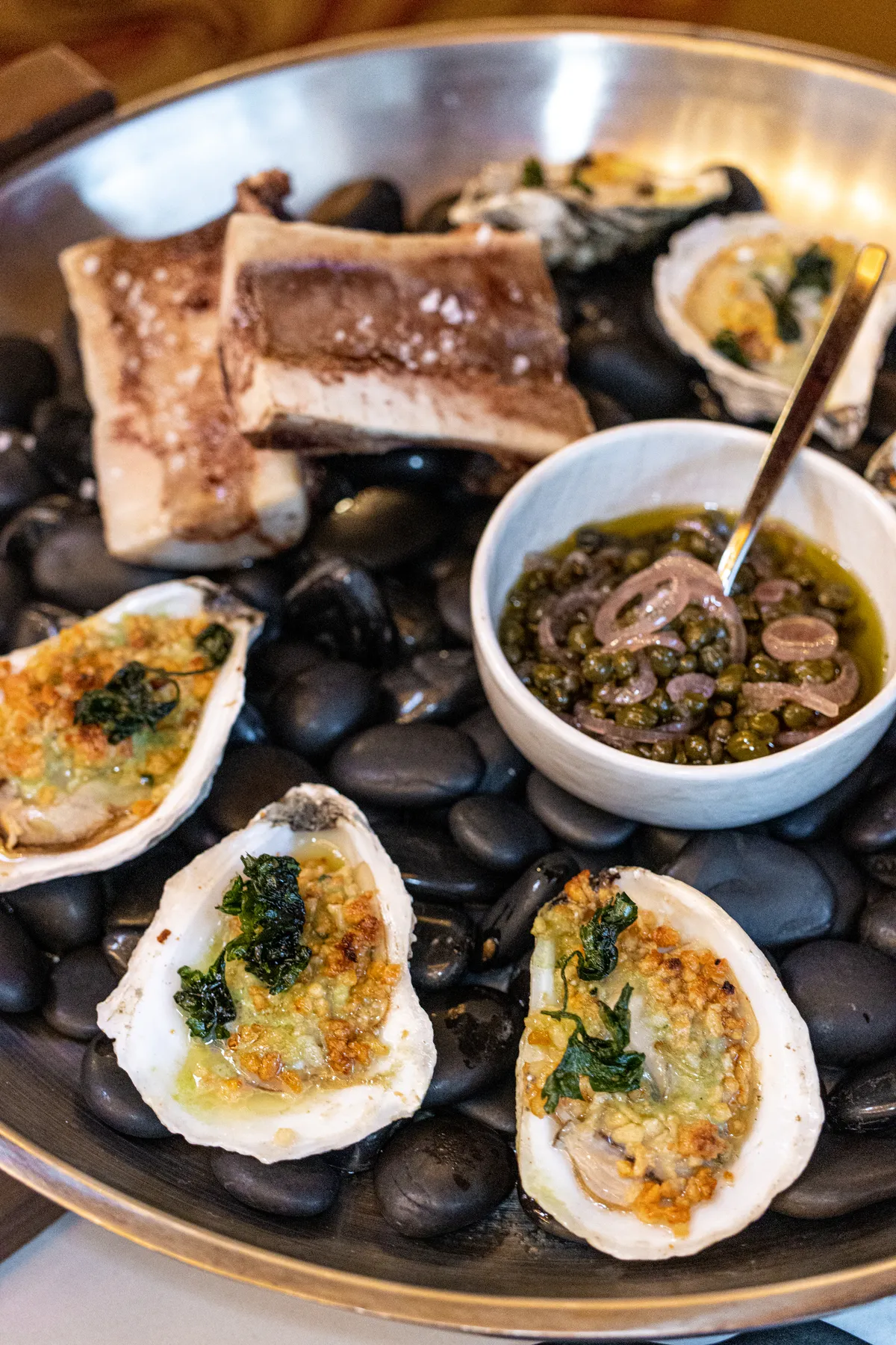 Roasted Oysters & Bone Marrow at Fawn & Fable. 6 oysters on a platter with bone marrow bones and capers. 