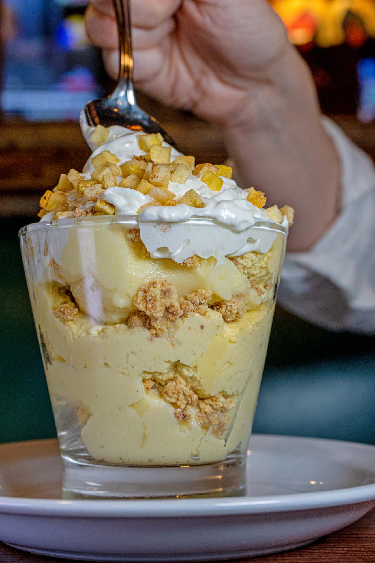 Banana Pudding Parfait on a plate with someone taking a spoonful