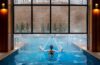 Heather from Better Living enjoying the heated indoor outdoor pool at The Swiftwater. Arching water features while snow falls outside the floor-to-ceiling windows