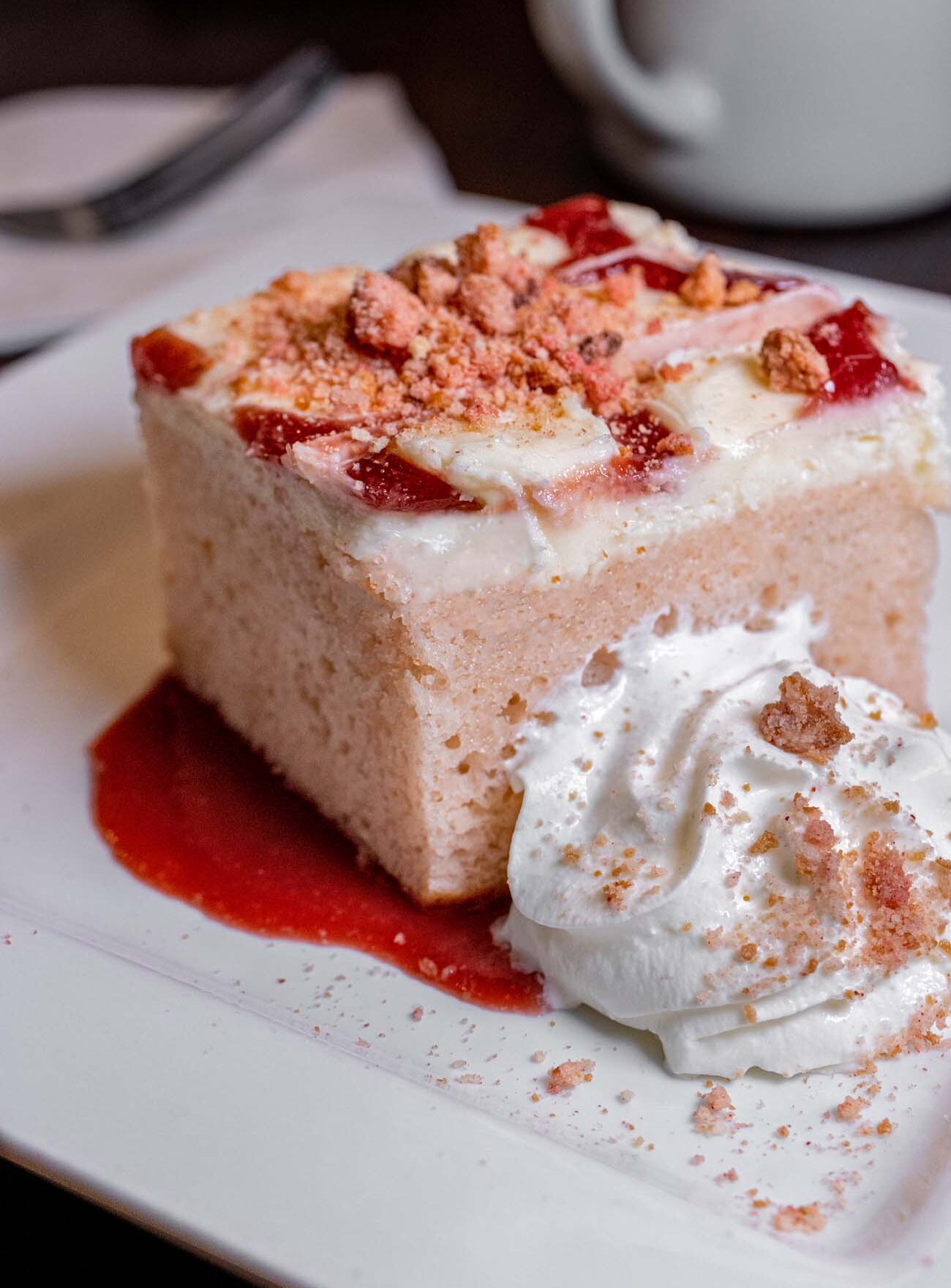 Hart's Strawberry Crunch Cake next to a mug of coffee.