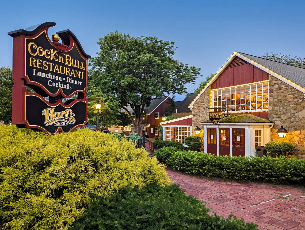 The exterior of Cock N Bull restaurant at Peddler's Village at twilight.
