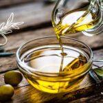 Olive oil pouring into a small clear bowl