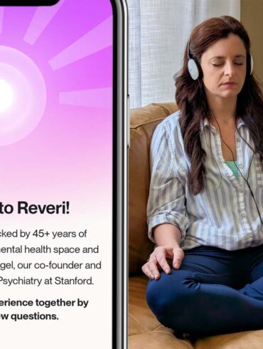 Split image showing a smartphone on the left displaying Reveri's welcome screen with a purple radial sunburst pattern and white center circle. The screen reads "Welcome to Reveri!" followed by text explaining "Our exercises are backed by 45+ years of clinical research in the mental health space and created by Dr. David Spiegel, our co-founder and the Associate Chair of Psychiatry at Stanford." Below states "Let's shape your experience together by answering a few questions." On the right side, a woman sits cross-legged on a tan leather couch wearing a light blue striped shirt and dark jeans. She has brown hair, closed eyes in a meditative state, and wears white headphones connected to a smartphone displaying a pink/orange gradient interface. Her hands rest naturally on her legs, and the setting shows a peaceful living room with natural lighting through sheer curtains and a textured throw pillow visible on the couch.