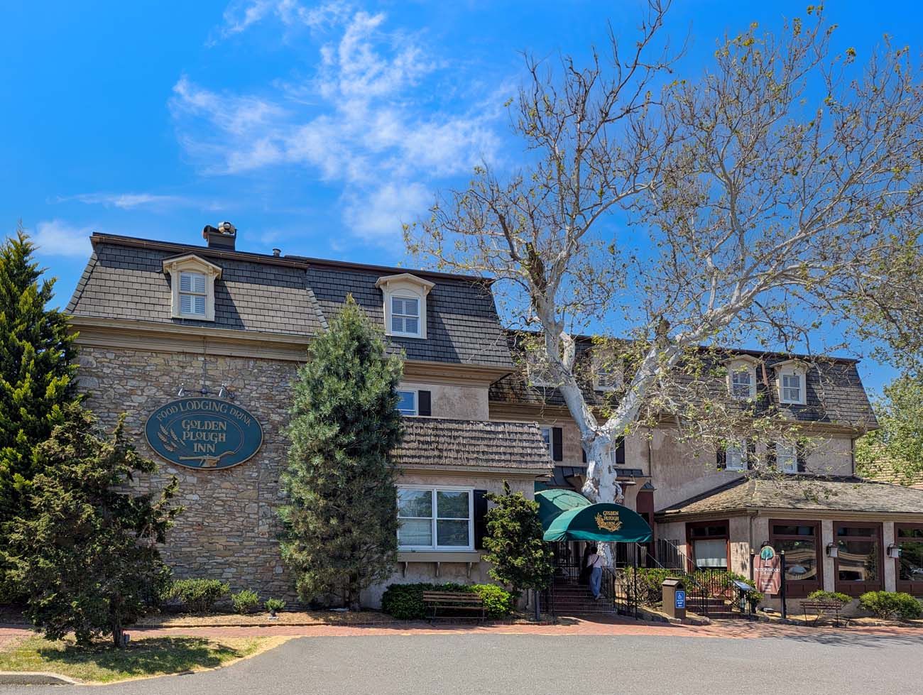 Exterior view of the Golden Plough Inn main building featuring colonial architecture at Peddler's Village.