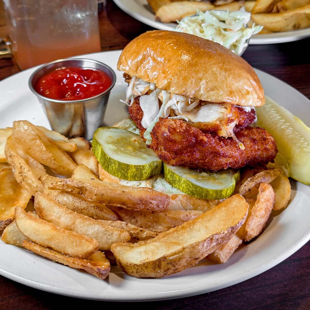 Nashville Chicken Sandwich at Hart's Tavern at Peddler's Village, crispy chicken cutlet with Nashville hot oil, dill pickles, green cabbage slaw on a brioche bun with fries.