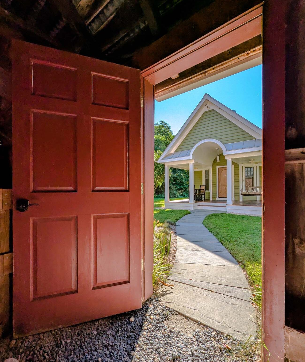 Brampton 1860 Review: A Timeless Retreat on the Eastern Shore 1 The famous red door entrance to Marley's Cottage at Brampton 1860, opening from the old barn parking area to reveal the bright, hidden cottage beyond.