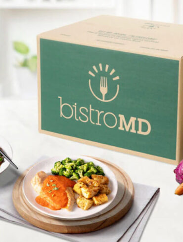 bistroMD meal deliver box with prepared plates and healthy, fresh veggies on a kitchen counter