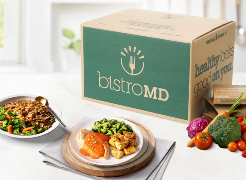 bistroMD meal deliver box with prepared plates and healthy, fresh veggies on a kitchen counter