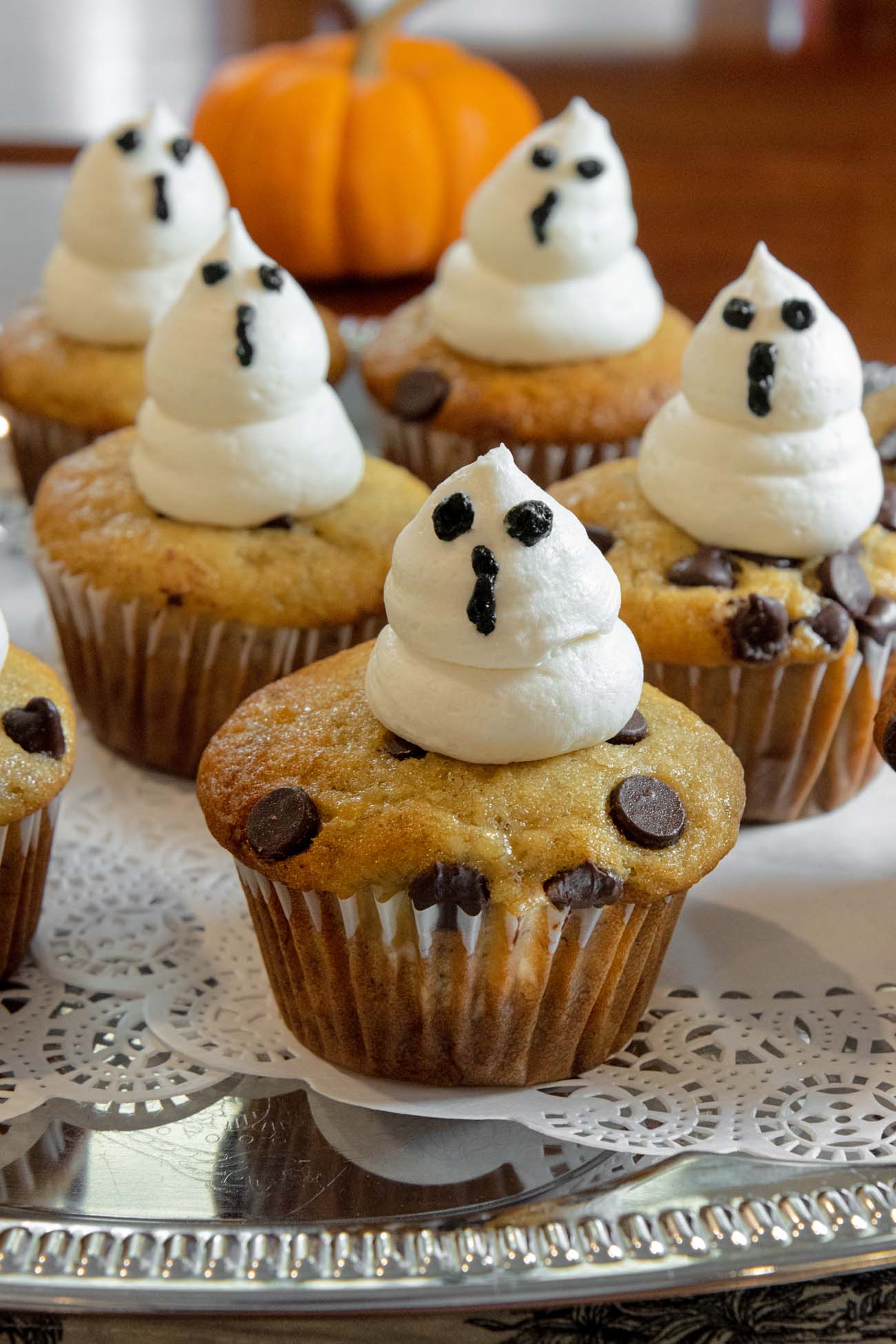 Food, Wine, and Fall Fun at Brampton 1860 - Chestertown, MD 12 Chocolate chip muffins decorated with white frosting ghosts with chocolate chip eyes and mouths, arranged on silver serving tray with pumpkin in background