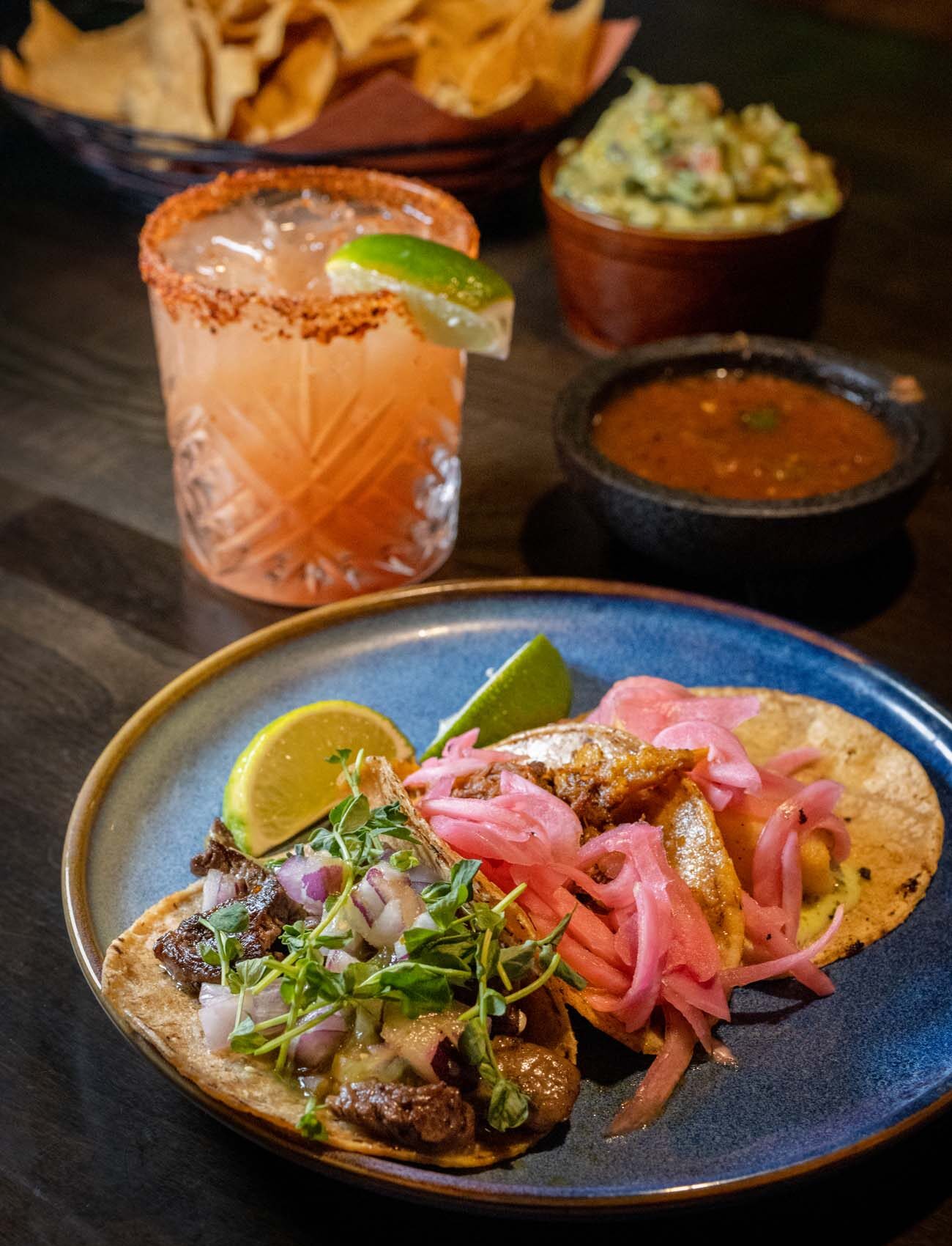 Taco Tuesday special featuring cochinita pibil tacos on handmade tortillas with guava margarita cocktail with Tajin rim, tortilla chips, fresh guacamole and salsa at authentic Mexican restaurant Felix's Cantina in Milford Pike County Pennsylvania