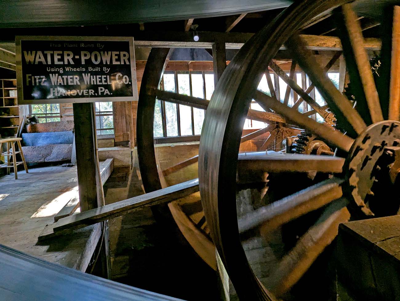 Historic 19th century three-story wooden waterwheel machinery and gears built by Fitz Water Wheel Company Hanover PA inside restored grist mill at The Waterwheel Cafe on National Register of Historic Places in Milford Pennsylvania