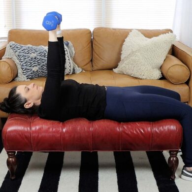 A woman working out with dumbbells in her living room