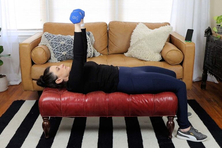 A woman working out with dumbbells in her living room