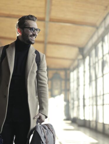 Man in Brown jacket Carrying Bag Smiling