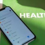 a mobile phone with health and wellness apps installed on a green folder that says health
