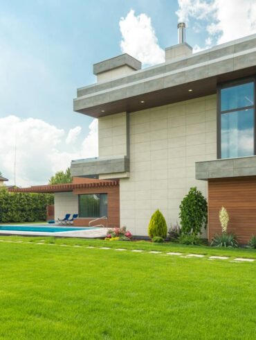 A Beautiful House with Swimming Pool Near the Garden with Green Grass