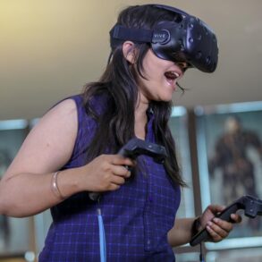 A woman playing a high activity VR headset video game increasing NEAT while having fun.