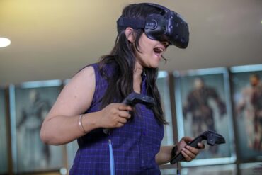 A woman playing a high activity VR headset video game increasing NEAT while having fun.