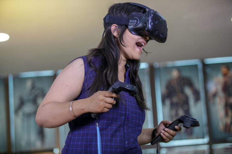 A woman playing a high activity VR headset video game increasing NEAT while having fun.