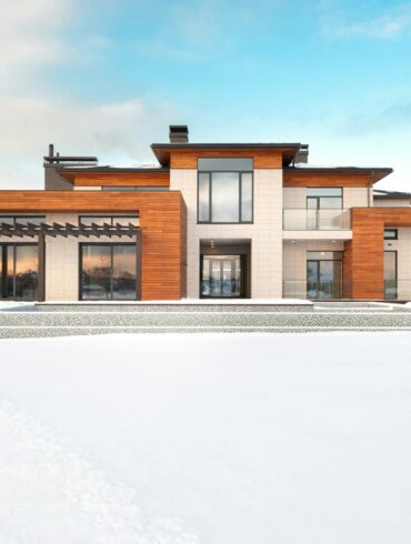 A modern home with large floor to ceiling windows, warm wood cladding, and a clean entryway, surrounded by snow on a bright winter day, showcasing how upgraded glazing and entryways can transform a home's curb appeal.