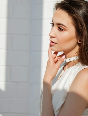 A young woman with glowing skin and natural makeup photographed in soft natural light, representing the subtle and refreshed look that defines high fidelity beauty standards in 2026 aesthetic medicine