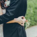 Bride and groom embrace holding white flowers on wedding day, planning an affordable and beautiful stress-free celebration