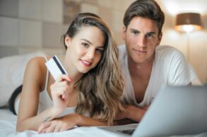 Young couple researching wellness financing options and payment plans for self-care services while reviewing wellness credit card alternatives on laptop at home