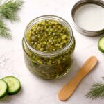 An open jar of dill on the counter looking fresh