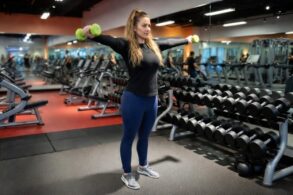 a woman at the gym working out her shoulders