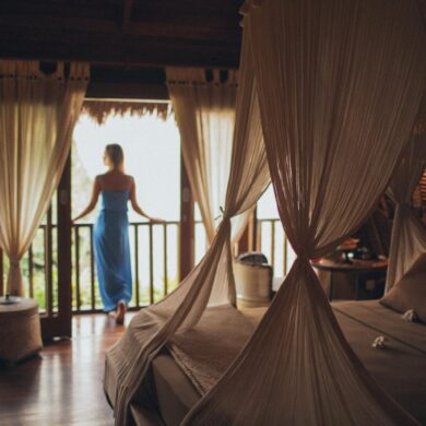 Woman Leaning on Handrail in a cozy and warmly lit lux bedroom