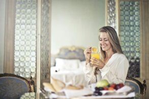 a happy woman starting her day with a fresh juice