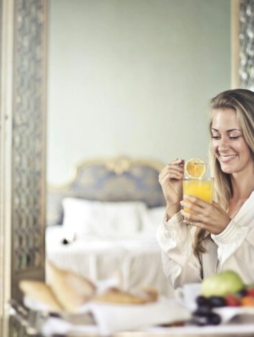 a happy woman starting her day with a fresh juice