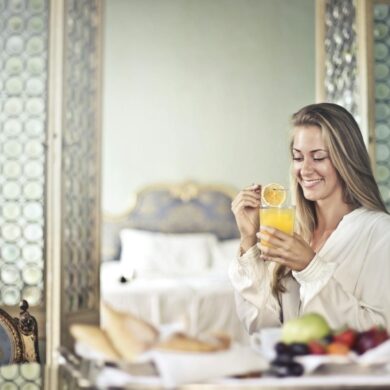 a happy woman starting her day with a fresh juice