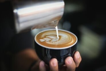 a person making a delicious cappuccino for a client