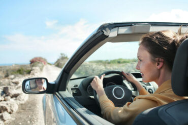 Woman in Brown Jacket Driving Car