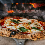 a fresh authentic italian pizza coming our of a real wood fired oven.