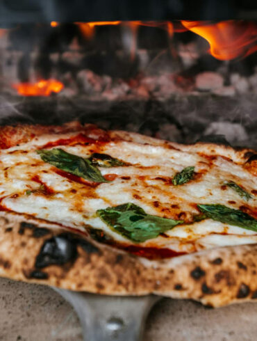 a fresh authentic italian pizza coming our of a real wood fired oven.