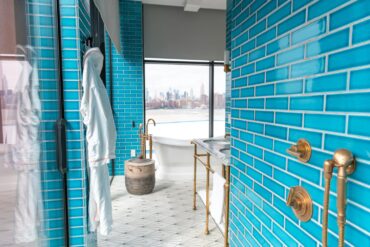 Elegant modern bathroom with vibrant Sukabumi shower tiles﻿ and skyline view, embodying luxury and style.