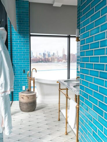 Elegant modern bathroom with vibrant Sukabumi shower tiles and skyline view, embodying luxury and style.