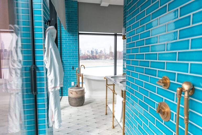 Elegant modern bathroom with vibrant Sukabumi shower tiles﻿ and skyline view, embodying luxury and style.