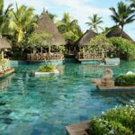 a tropical resort pool offering luxury, privacy, and relaxation. cabanas in the background.